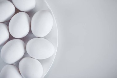 Beyaz masa arkaplanındaki yumurtaların üst görünümünü kapat