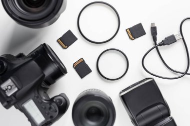 Modern DSR fotoğraf makinesinin üst görünümü, lensler ve ekipmanlar beyaz masa arkaplanı üzerinde