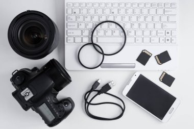 Kamera, lensler, fotoğraf ekipmanları ve dizüstü bilgisayarın beyaz masa arkaplanı