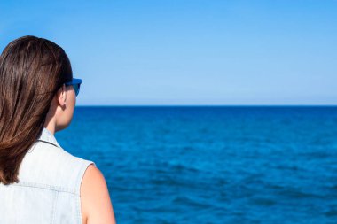 Yaz ve tatil konsepti. Plaj geçmişinden genç bir kadının arka planı.