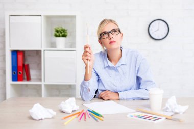 Yaratıcılık, fikir ve ilham konsepti - boya fırçasıyla yaratıcı genç kadın bir şey düşünüyor