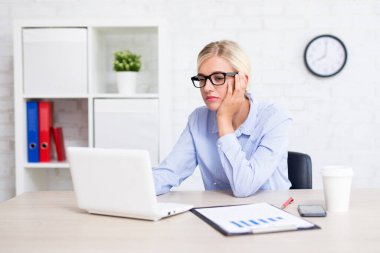 Ofiste bilgisayarla çalışan sıkıcı ve yorgun iş kadını.