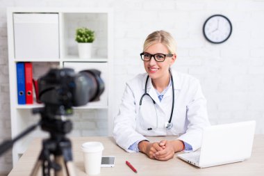 Neşeli güzel kadın doktor. Tıp ve sağlık hakkında video kaydediyor.