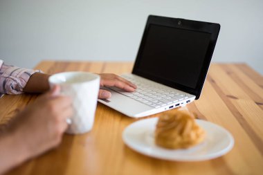 Bilgisayarı boş ekranla kapat ve kadın eli ile kahve ya da çay.