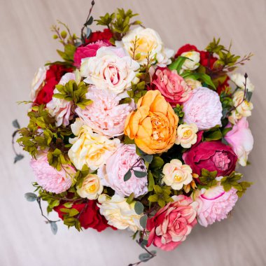 Tahta masa arkasında bir demet yaz çiçeğinin üst görüntüsünü kapat