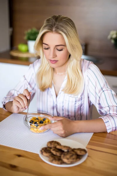 Mutfakta Oturup Sağlıklı Bir Kahvaltı Yapan Pijamalı Mutlu Bir Kadının — Stok fotoğraf