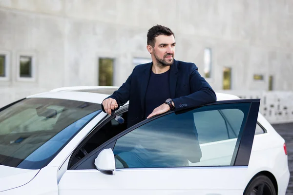 現代の車の近くでポーズをとるハンサムな男の運転手の肖像画 — ストック写真