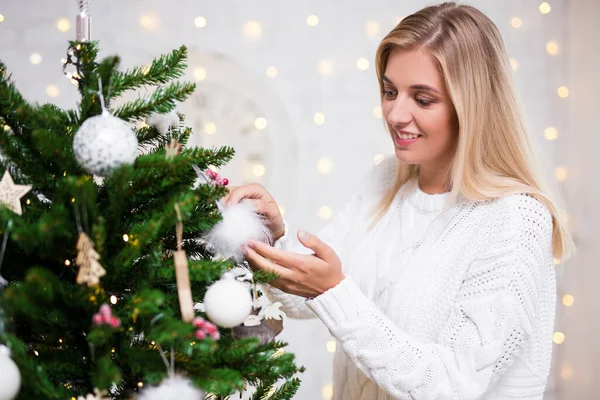 家でクリスマスツリーを飾る若い女性の肖像画 — ストック写真