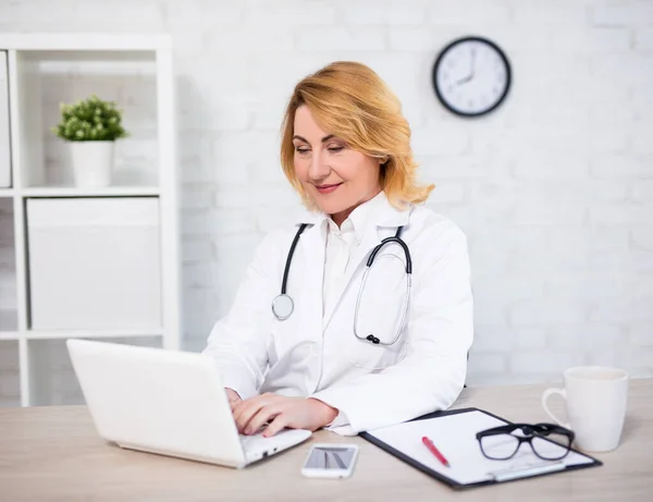 Vrolijke Volwassen Vrouw Arts Verpleegkundige Werken Met Laptop Modern Kantoor — Stockfoto