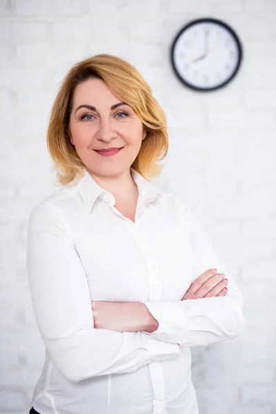 Reife Geschäftsfrau Posiert Über Weißer Ziegelwand Mit Bürouhr — Stockfoto