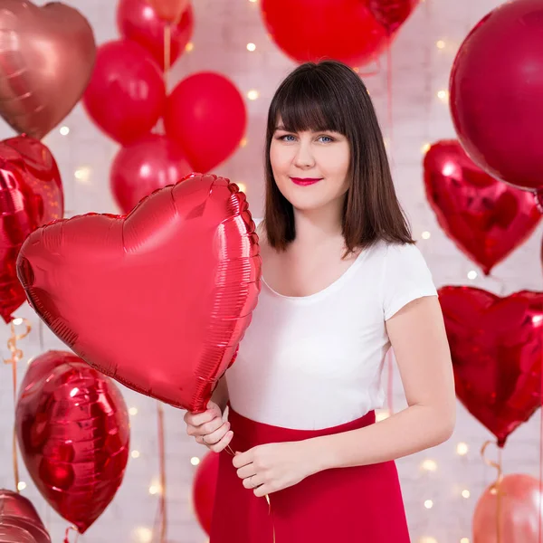 バレンタインデーのコンセプト 赤いハート型の風船でポーズをとる若い美しい女性の肖像 — ストック写真