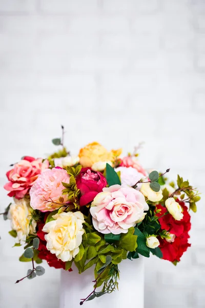 コピースペース付きの白いレンガの壁の背景に丸い箱の中の夏の花のクローズアップ — ストック写真