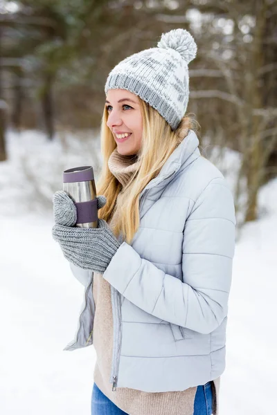 在冬季公园或森林里 年轻美丽的金发女子与热咖啡的肖像 — 图库照片