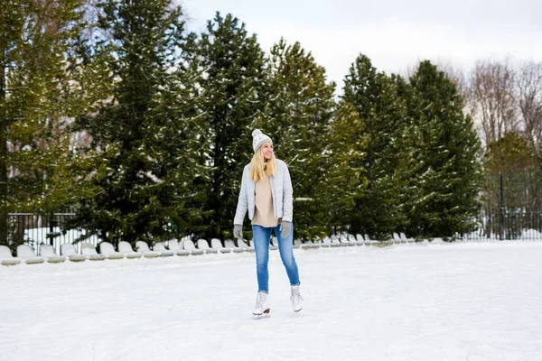 年轻女子在冰上滑冰与花样滑冰在冬季公园的肖像 — 图库照片