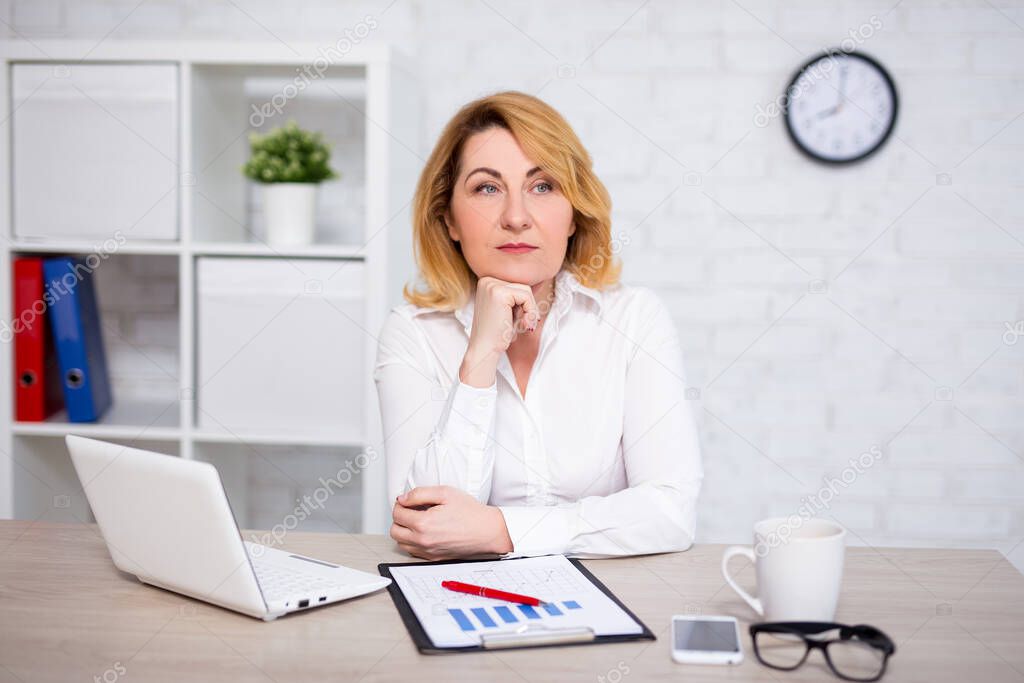 sad mature business woman sitting in modern office