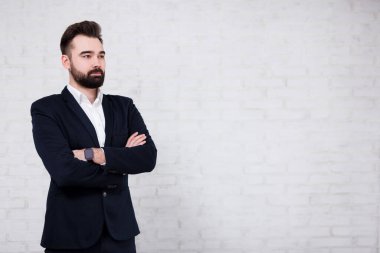 Genç yakışıklı sakallı iş adamı ve beyaz tuğla duvarın üzerinde kopya alanı