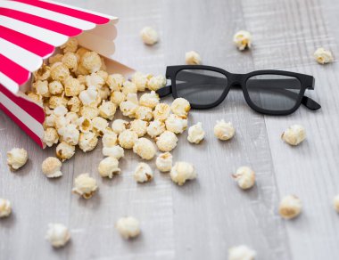 Sinema konsepti - 3 boyutlu bardaklar ve tahta masa arkasında patlamış mısır