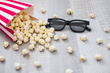 Sinema konsepti - 3D bardaklara yakın ve tahta arka planda patlamış mısır