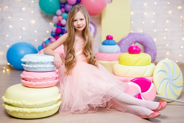 巨大なマカロン ドーナツ カップケーキの装飾を持つかわいい女の子の肖像画 — ストック写真