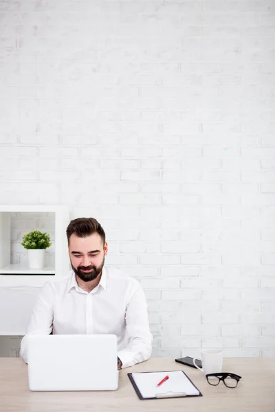 Ofiste Dizüstü Bilgisayar Kullanan Neşeli Sakallı Adamının Portresi Beyaz Tuğla — Stok fotoğraf