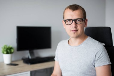 Modern ofiste bilgisayarlı genç bir adamın portresi.