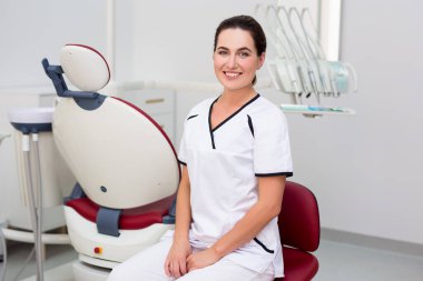 Modern diş kliniğinde genç ve güzel bir dişçinin portresi.