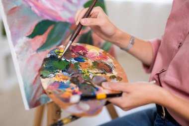 sanat, yaratıcılık ve ilham konsepti - evde veya stüdyoda boya fırçasıyla resim yapmak için ellerinizi kapatın