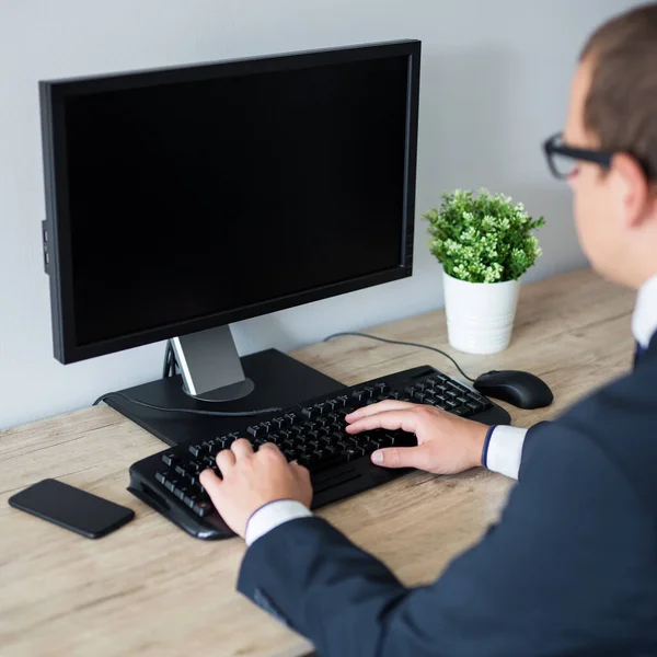 バックオフィスでコンピュータを使用して若いビジネスマンのビュー 空白の画面上のコピースペース — ストック写真