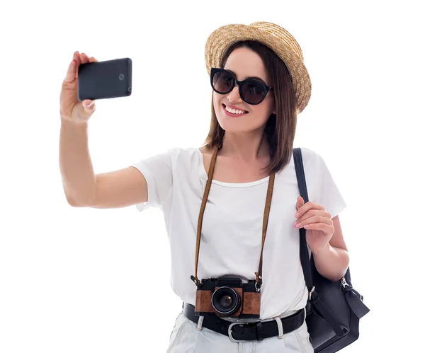 年轻美丽的女游客头戴草帽的肖像 用白色背景隔离的智能手机自拍 — 图库照片