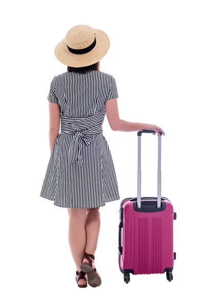 バックビューの若い女性の観光客の藁帽子とピンクのスーツケースと夏のドレス白の背景に隔離された — ストック写真