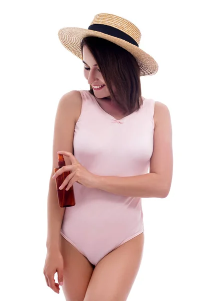 Jonge Vrouw Roze Badpak Strohoed Aanbrengen Zonnebrandcrème Spray Geïsoleerd Witte — Stockfoto