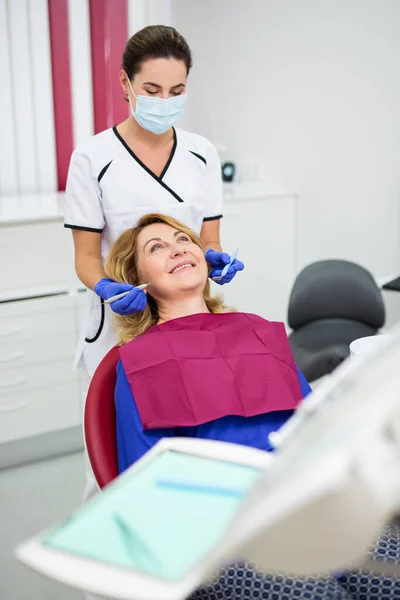 Giovane Dentista Femminile Con Felice Paziente Donna Matura Presso Clinica — Foto Stock