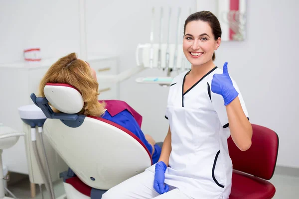 Portret Van Jonge Positieve Vrouwelijke Tandarts Duimen Omhoog Patiënt Zitten — Stockfoto