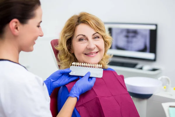 Tandarts Controleren Selecteren Kleur Van Implantaten Voor Vrolijke Volwassen Vrouw — Stockfoto