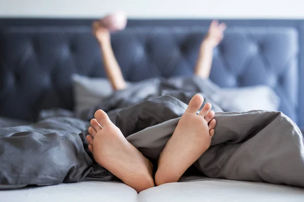 早上好 女性的手和腿从卧室的毛毯上伸出来 — 图库照片