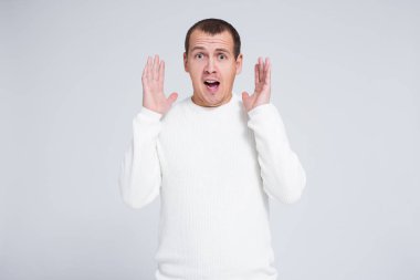 Komik, şaşırmış bir adam bir şey hakkında bağırıyor ve gri arkaplan üzerine boşluk kopyalıyor.