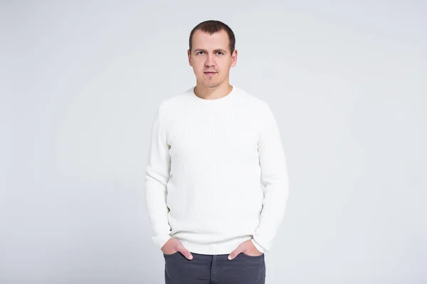 暖かい冬のセーターを着た若い男の肖像画がグレーの背景にコピースペースでポーズ — ストック写真
