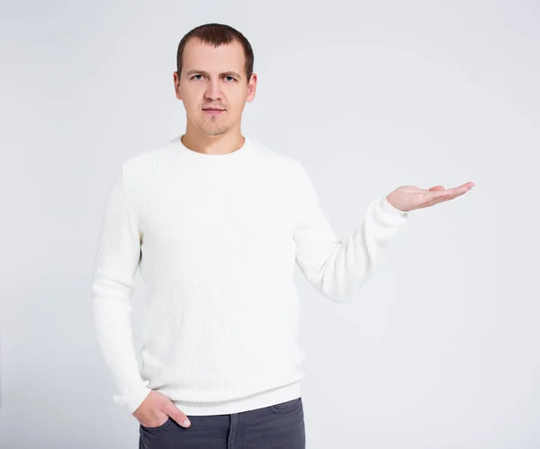 Retrato Hombre Joven Suéter Invierno Caliente Sosteniendo Algo Sobre Fondo —  Fotos de Stock