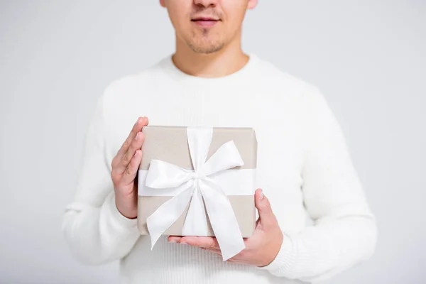 クリスマスやバレンタインデーのコンセプト グレーの背景に男性の手でギフトボックスのクローズアップ — ストック写真