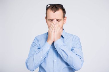 Gri arkaplanda fotokopi alanı olan genç ve yorgun iş adamının portresi