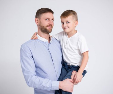 Beyaz arka planda genç baba ve küçük oğlun portresi.