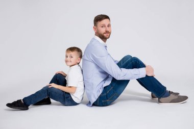 Mutlu aile portresi. Beyaz arka planda oturan tatlı bir oğlu olan baba.