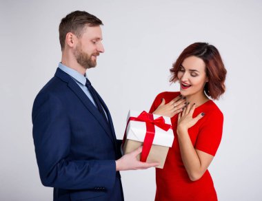 Sevgililer günü, ilişki ve aşk konsepti - beyaz arka planda eşine veya kız arkadaşına hediye kutusu veren yakışıklı bir adamın portresi