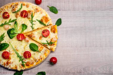 Domatesli ve otlu pizzanın ahşap masa arkası manzarası