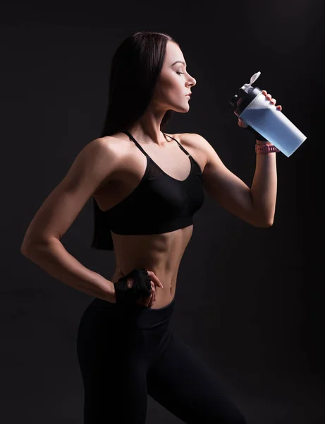 黒を基調としたスポーツウェア飲料タンパク質カクテルの美しい運動女性 — ストック写真