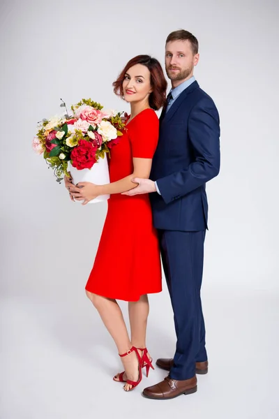 バレンタインデーや誕生日の驚きのコンセプト ハンサムな男驚くべき彼のガールフレンドとともに花上の白い背景 — ストック写真