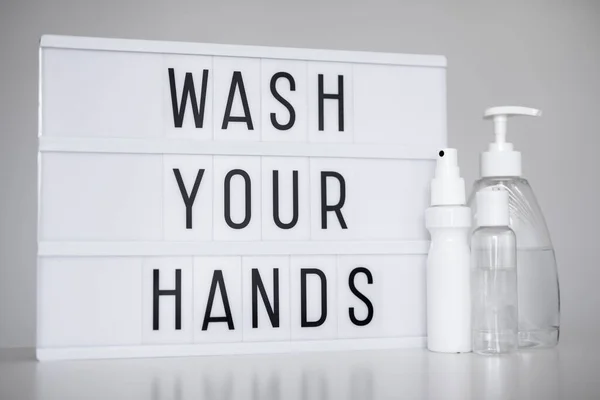 コロナウイルスのパンデミックと手の衛生の概念 白い背景に消毒剤や液体石鹸のあなたの手のメッセージとボトルを洗うライトボックス — ストック写真
