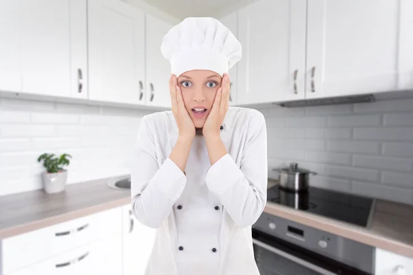 穿着厨师制服穿着白色现代厨房的滑稽女人 — 图库照片