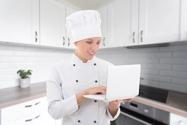 Młoda Kobieta Szef Kuchni Mundurze Laptopem Białej Nowoczesnej Kuchni — Zdjęcie stockowe