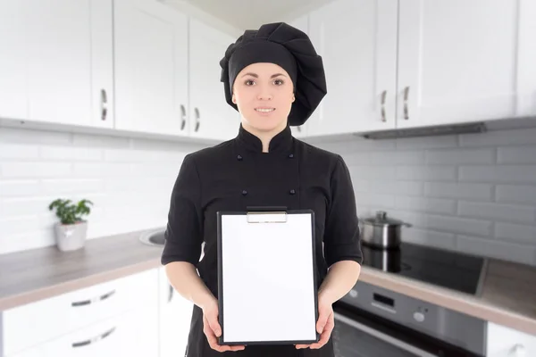 Young Cook Woman Black Uniform Showing Blank Clipboard Modern Kitchen — Stock Photo, Image